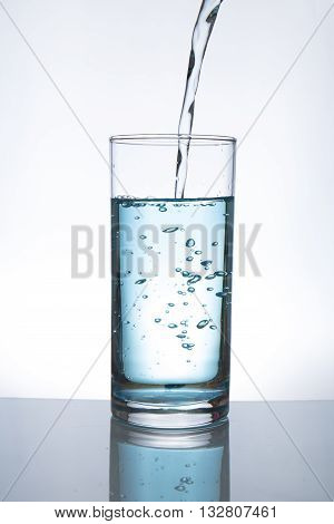 Concept of drinking. Pouring water from into glass