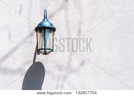 Vintage cast iron electric street lamp on the textured wall.