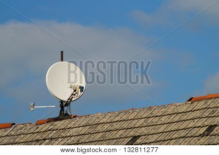 Satellite dish on a roof with defective roof ridge .