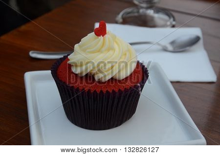 red velvet cupcake with heart ornament on