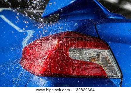 Car detailing series : Water splashing on blue car taillights