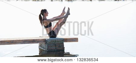 Pilates yoga workout exercise outdoor in the lake pier