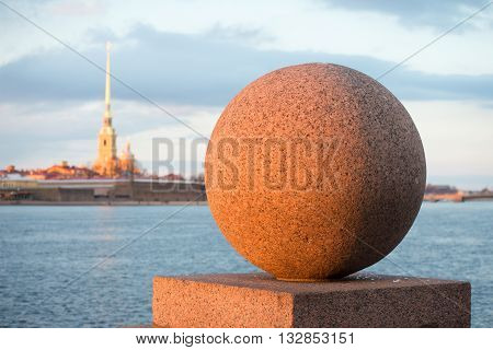 Granite ball close up in the light of the setting spring sun. Vasilievsky island, Saint Petersburg, Russia