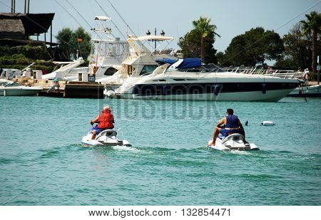 PUERTO SOTOGRANDE, SPAIN - JULY 18, 2008 - Men on jet skis in the marina Puerto Sotogrande Cadiz Province Andalucia Spain Western Europe, July 18, 2008.