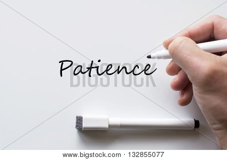 Human hand writing patience on whiteboard .