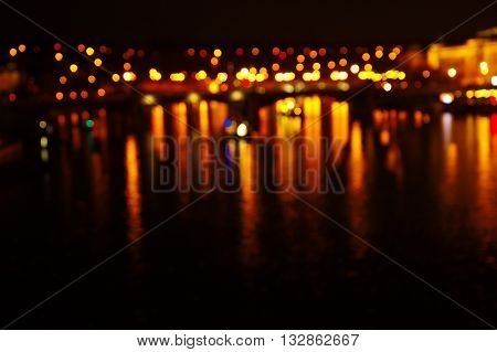 blur light reflection of city in water at night background