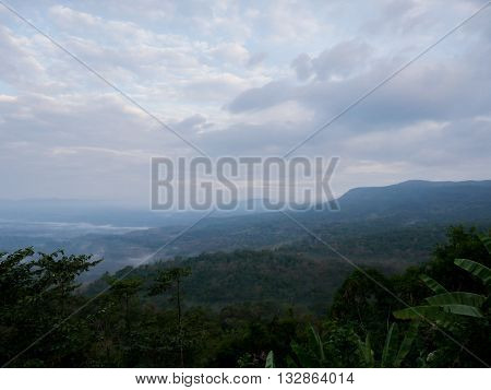 Scenic view on the gloomy atmosphere in the morning. Overlooking the misty with forests mountains and sky.