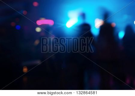 blur people at blue light party in pub at night background