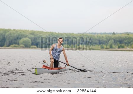 Chelyabinsk Russia - May 28 2016: athlete canoeist with an oar in a canoe after finish during Ural championship in rowing