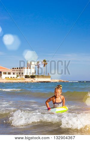 Cute Girl In Swimsuit Bathes On Waves In Sea. Sunny Mediterranean Beach, Cala Del Palangre, Torrevie