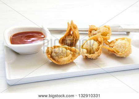 deep fried won ton with sweet and sour sauce on tray