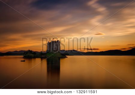 Stalker Castle reflection in orange sunset light Highlands Scotland