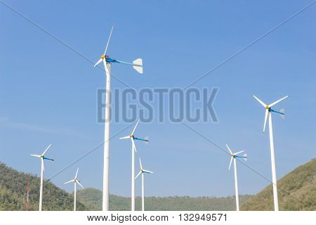 Wind Turbine for alternative energy on background Sky and Mountain.