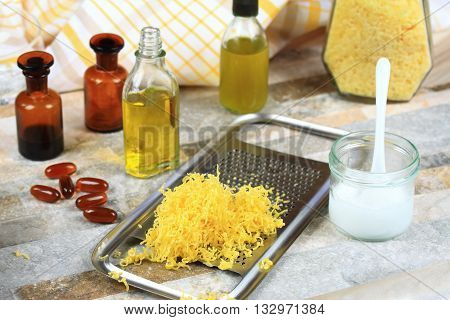 Homemade balsam on lips. Lip balsam made from olive and coconat oil with beeswax. Lis basam decorated with daisy. Homemade cosmetics. Organic balsam on lips.