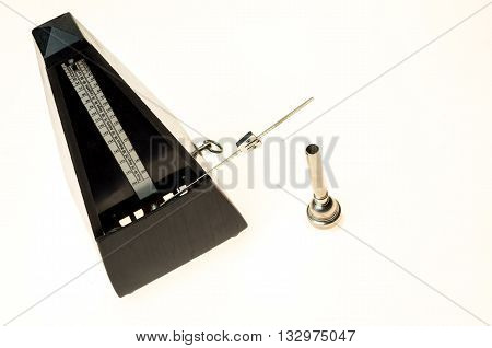 Metronome and mouthpiece of a trumpet isolated on a blank white background as copy space