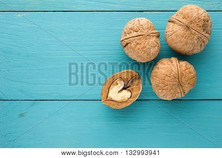 The concept of healthy eating. Love for healthy food, nuts. The heart of walnut on a blue wooden background