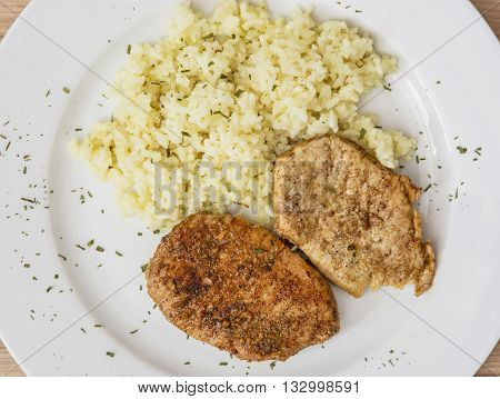 Pork tenderlion with rice on the white plate. Food theme. International cuisine. Restaurant menu.