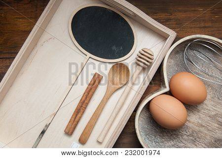 Raw Eggs With Wooden Spooon And Baking Tools. Bake Or Food Background. Dark Rustic Wooden Background