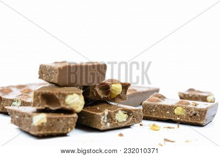 Stack Of Chocolate Pieces With Nuts In Close-up And Isolated On White Background.