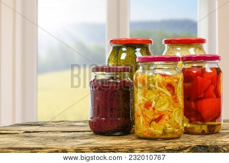 Composite Image Of Jars With Variety Of Homemade Pickled Vegetables On A Wooden Vintage Table And On