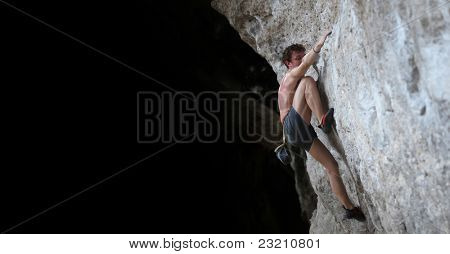 Hombre desnudo de la joven semi escalada sobre una roca sin aseguramiento