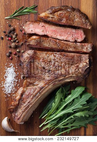 Grilled Cowboy Beef Steak, Herbs And Spices On A Wooden Board. Top View.
