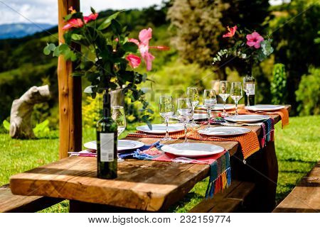 Table Set For Family In Beautiful Location. Wooden Table, Flower Decoration, Garden Setting, Sunny D