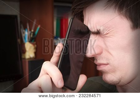 The Guy Tightly Squeezed His Eyes, Closed The Rum With A Black Smartphone, In The Workplace