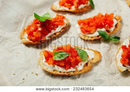 Italian Bruschetta On A Wooden Board With Feta Cheese And Herbs