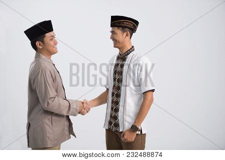 Two Men Pose In Front Of The Camera. Embracing Each Other During Eid Mubarak Celebration