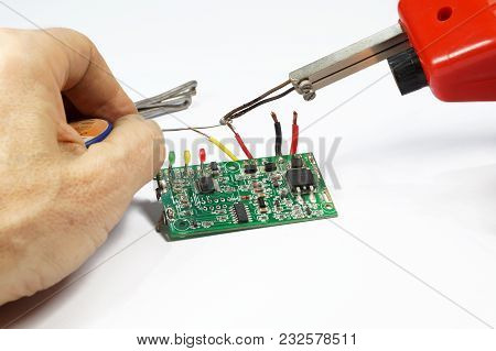 Soldering Operation. Transformer Soldering Iron, Hand, Solder. Soldering Of Wires On A Printed Circu