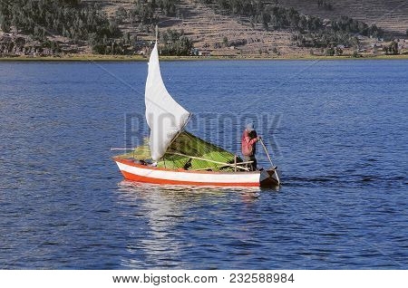 Peruvian Man Sails By Boat With Cane On Lake Titicaca. Peru.