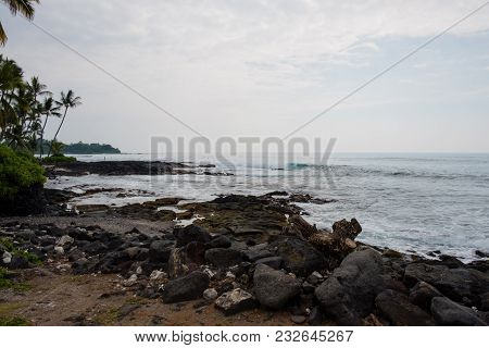 Beach And Lava Rock With A Nice Surf Spot At Kona Hawaii On The Big Island.