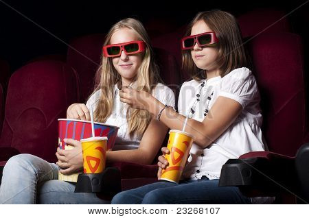 Zwei schöne Mädchen, die einen Film im Kino