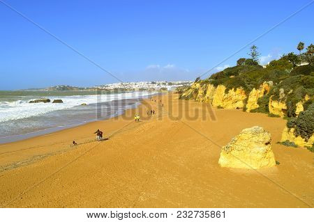 Albufeira, Algarve, Portugal - March 11, 2018 : People Walking In The Springtime Sun On Albufeira Be