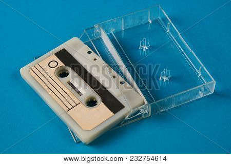Blank Cassette Tape Box On Blue Background. Vintage Cassette Tape Case With Retro Cassette Mockup. P