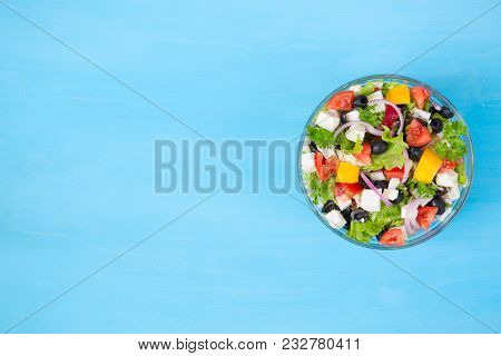 Greek Salad On Blue Wooden Background, Top View.