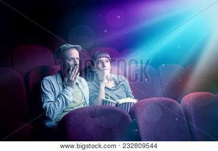 Teenager couple cuddling and watching the climax part of the movie