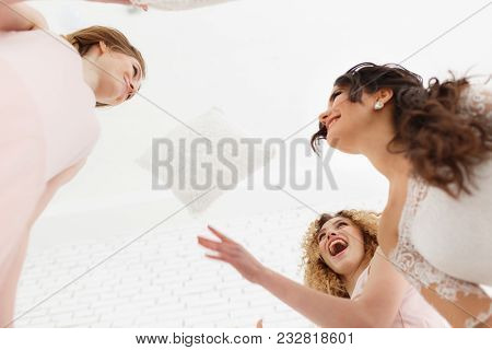 Feeling So Happy. View From Below Of Attractive Young Bride And Two Bridesmaids Making Faces While T