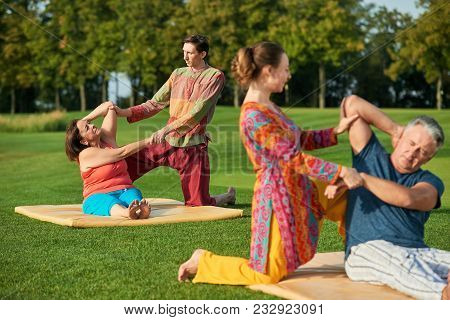 Thai Massage For Old People. Yoga Exercises Outdoor At Sunny Sumemr Park.