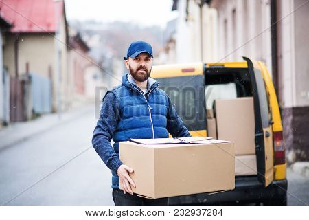 Delivery Man Delivering Parcel Box To Recipient - Courier Service Concept.
