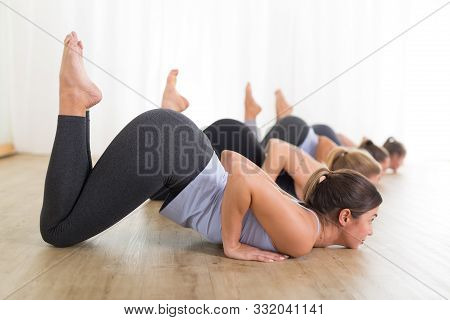Group Of Young Sporty Sexy Women In Yoga Studio, Practicing Yoga Lesson With Instructor, Forming A L