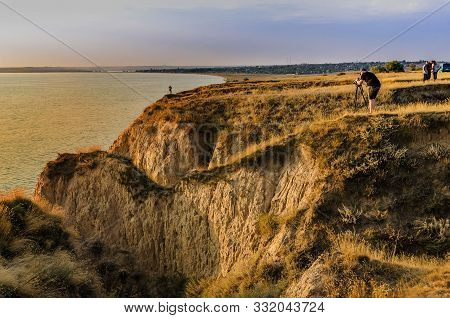 Ukraine, Kherson Region, September 6, 2019, A Man Photographs A Model On The Incredible, Steep Shore