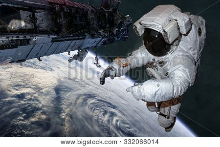 Astronaut And Iss In Orbit Of Earth. Solar System. Science Fiction. Elements Of This Image Furnished