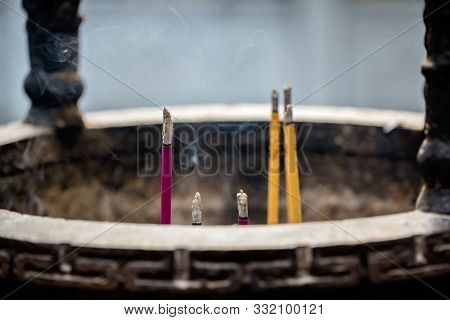 Large Bronze Brass Pot With Incense Sticks Burning Inside In The Courtyard Of The Buddhist Temple At