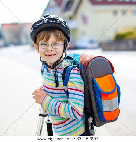 Active School Kid Boy In Safety Helmet Riding With His Scooter In The City With Backpack On Sunny Da