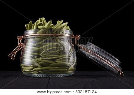 Jar Of Foglie Spinach Pasta On Wooden Table Isolated On Black Background