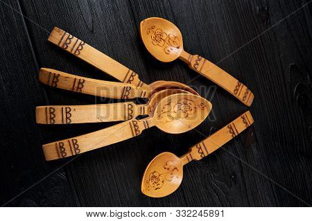 Old Russian Wooden Spoons With Hand Engraving And Pattern On A Black Wooden Background