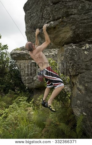 A Rock Climber Ascending A Bolder In Mpumalanga, South Africa.