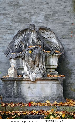 Fallen Angel At With Autumn Leaves At A Cemetery